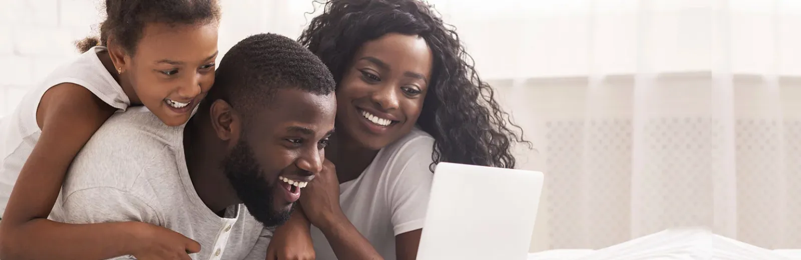 Family laughing together watching computer