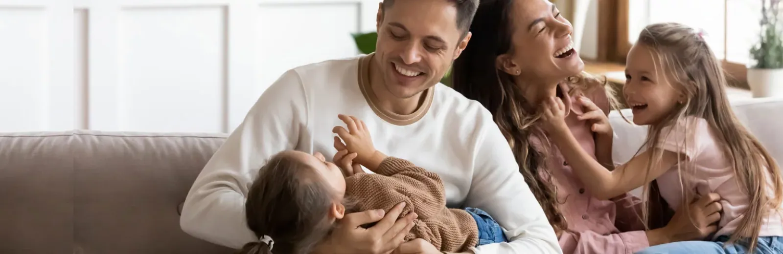 Mom and dad tickling kids