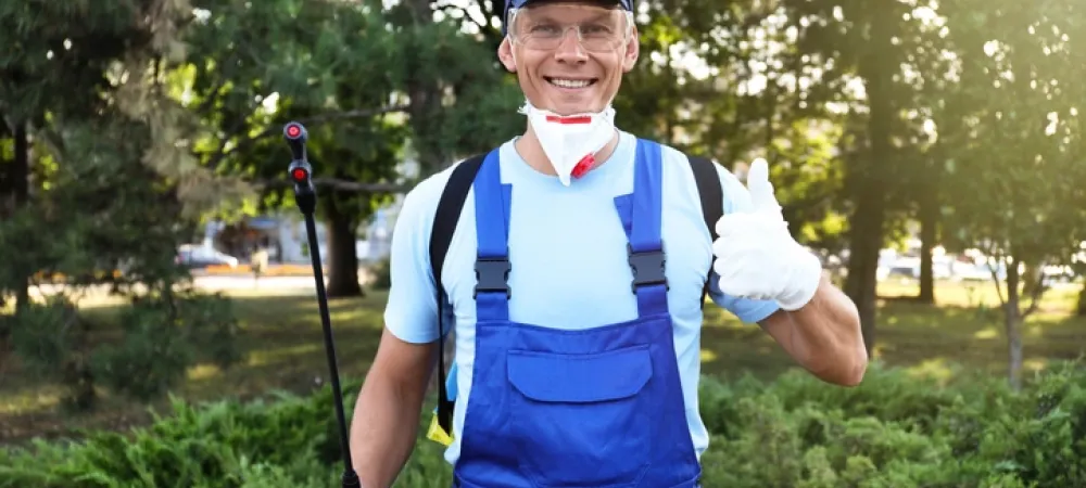 pest control tech in a blue outfit